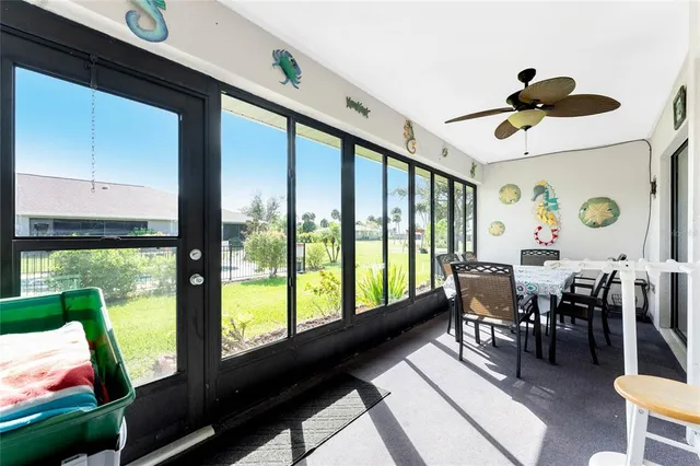 a view of a dining room with furniture a chandelier and a large window