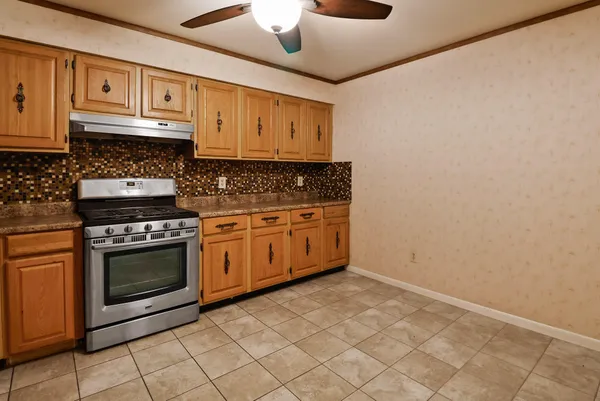 a kitchen with stainless steel appliances granite countertop a stove a cabinets and entryway
