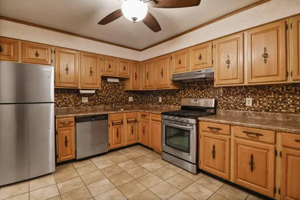 a kitchen with stainless steel appliances granite countertop a refrigerator a stove a sink and dishwasher
