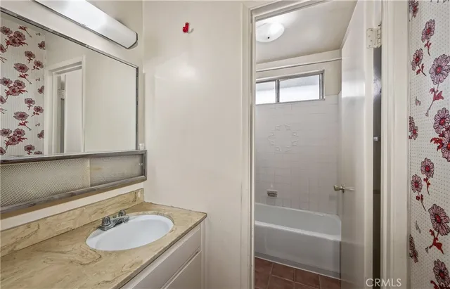 a bathroom with a granite countertop sink a mirror a shower and a bathtub