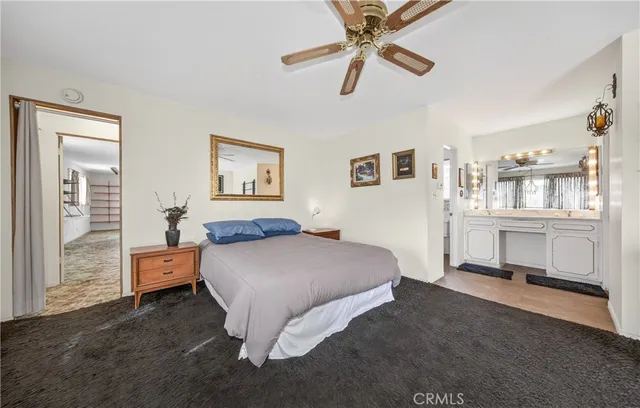 a spacious bedroom with a bed and ceiling fan