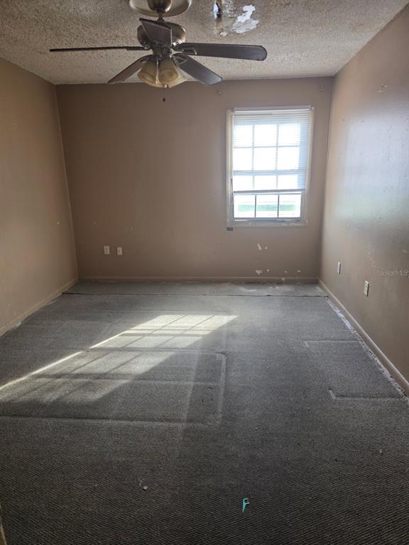 2789 L B McLeod Road, Unit D Orlando, FL 32805 - Photo 2 of 5 en empty room with windows and chandelier fan