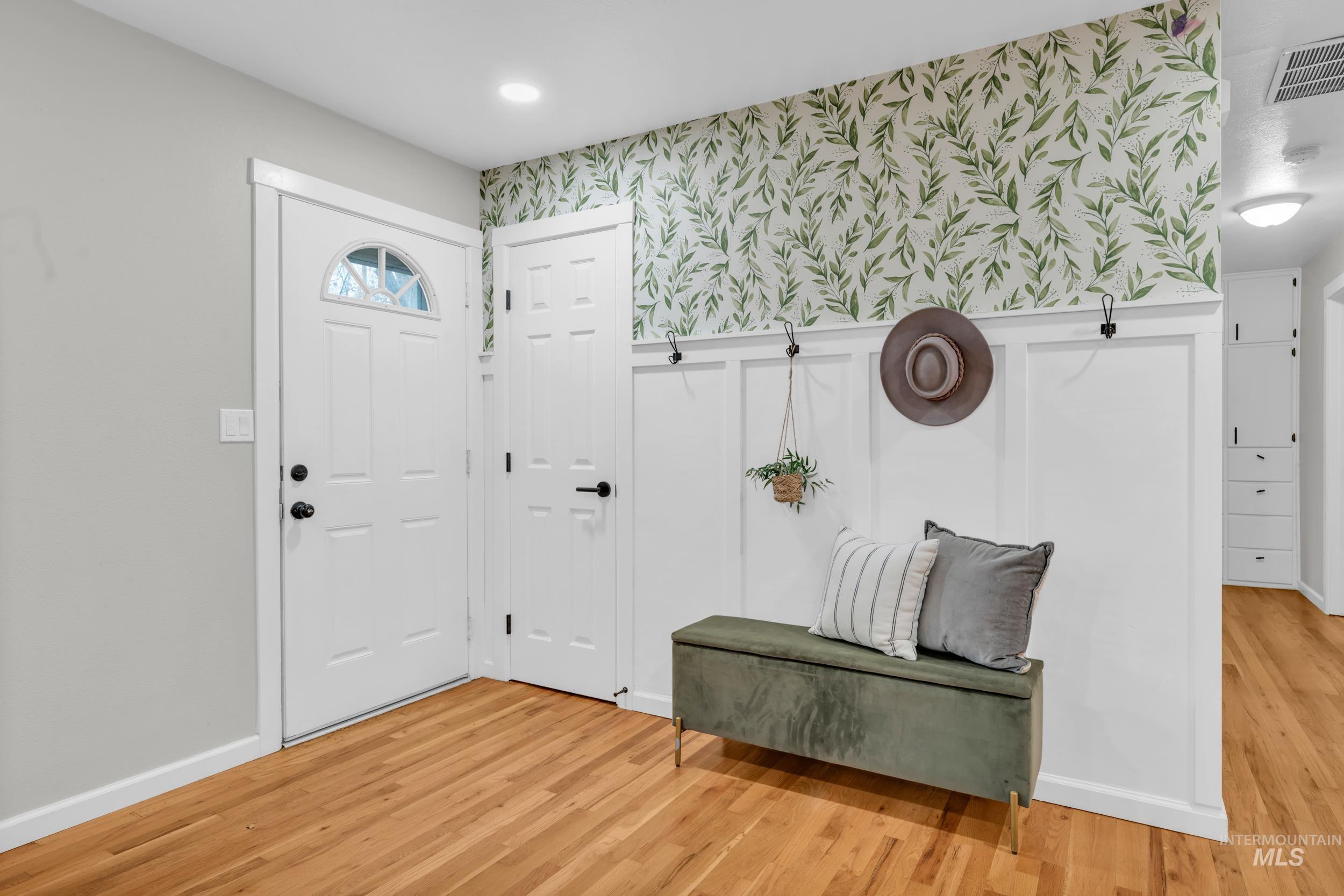 2908 Meadowbrook Drive Boise, ID 83705 - Photo 5 of 29 Entryway featuring wallpapered walls, a wainscoted wall, light wood-type flooring, and a decorative wall