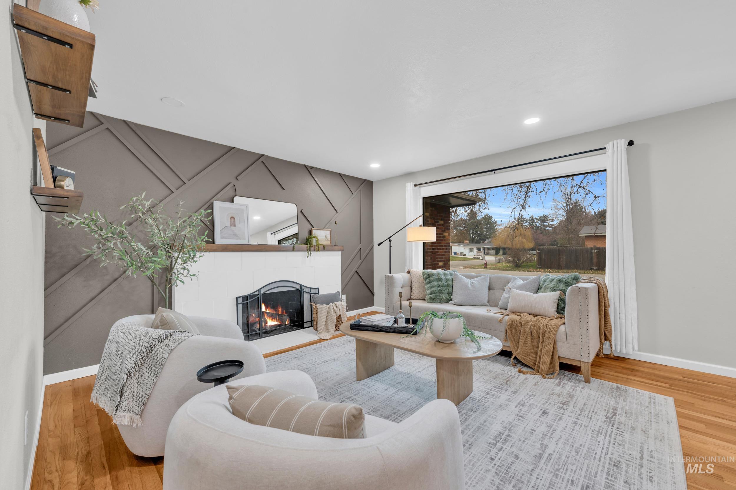2908 Meadowbrook Drive Boise, ID 83705 - Photo 7 of 29 Living room with light wood-style flooring, an accent wall, a lit fireplace, and recessed lighting