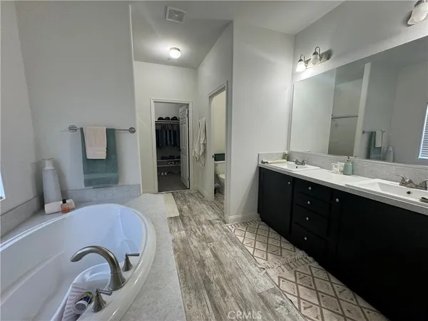 a spacious bathroom with a double vanity sink a mirror and a shower