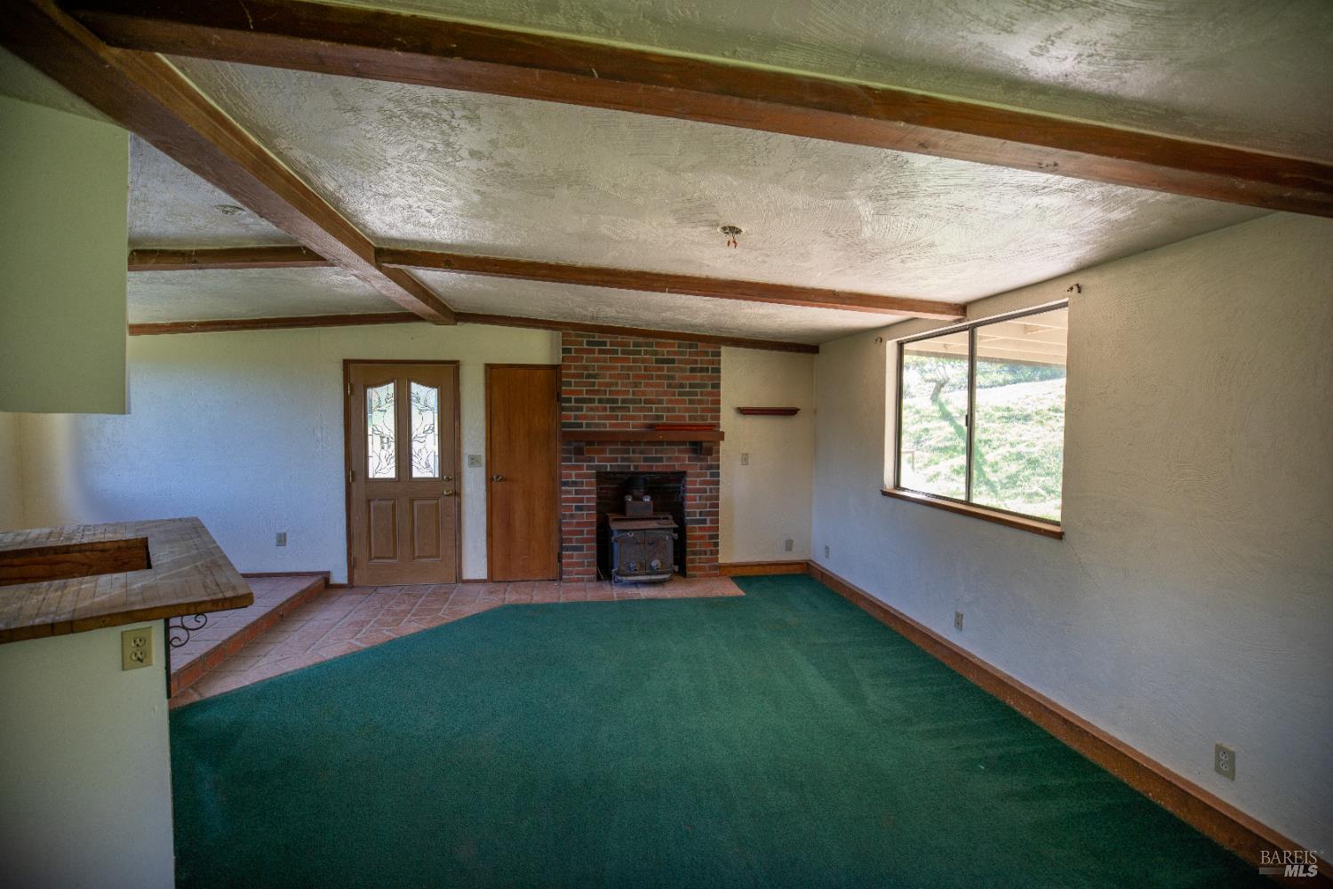 2300 Brack Road Healdsburg, CA 95448 - Photo 9 of 41 a view of an empty room with a fireplace and a window