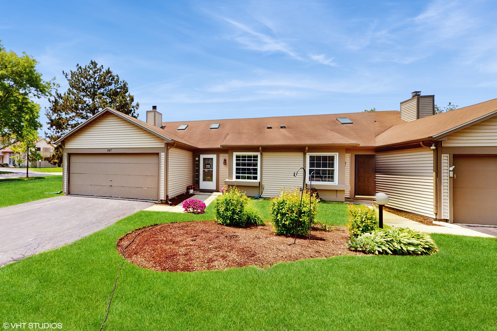 267 Juniper Circle Streamwood, IL 60107 - Photo 3 of 25 a front view of a house with a garden and plants