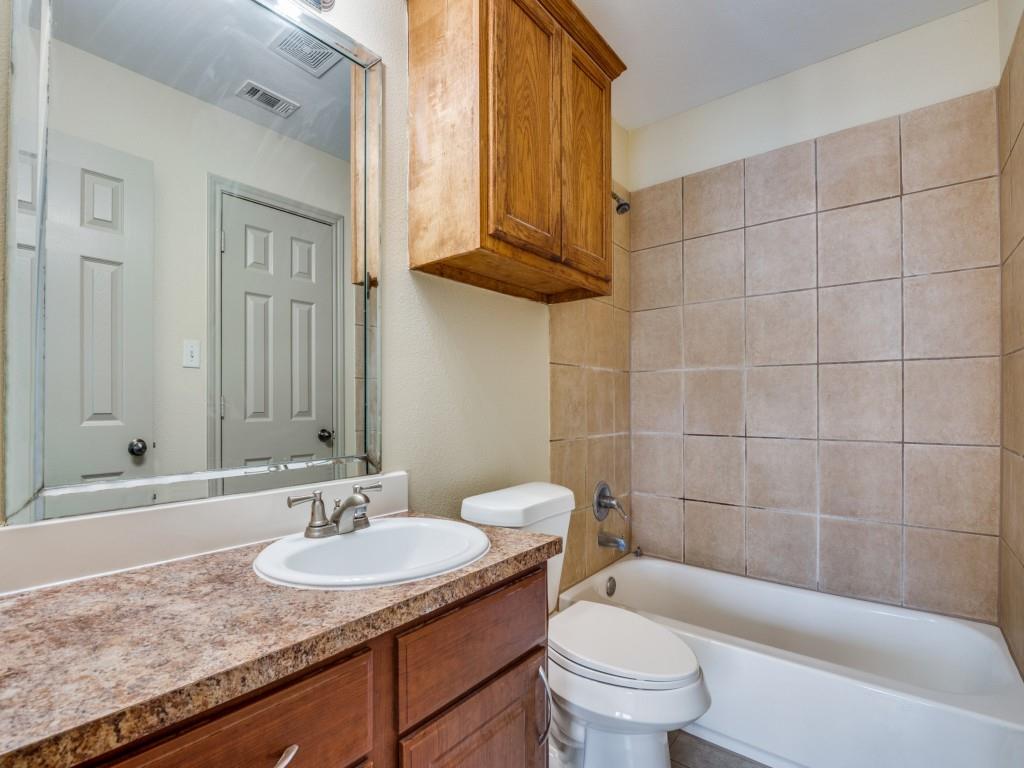 1439 North Bluegrove Road Lancaster, TX 75134 - Photo 11 of 12 a bathroom with a granite countertop sink a toilet a mirror and shower