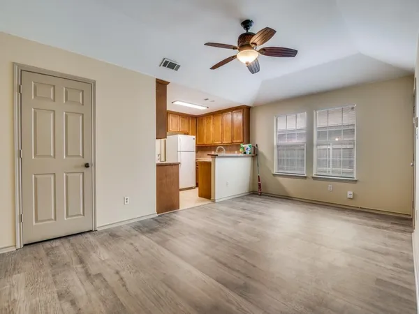a view of a kitchen with a stove cabinets a ceiling fan and wooden floor