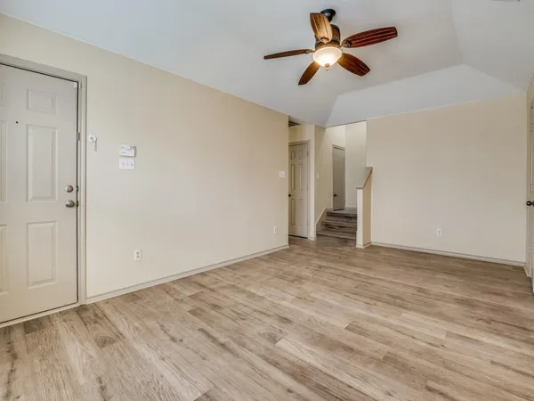 a view of empty room with wooden floor