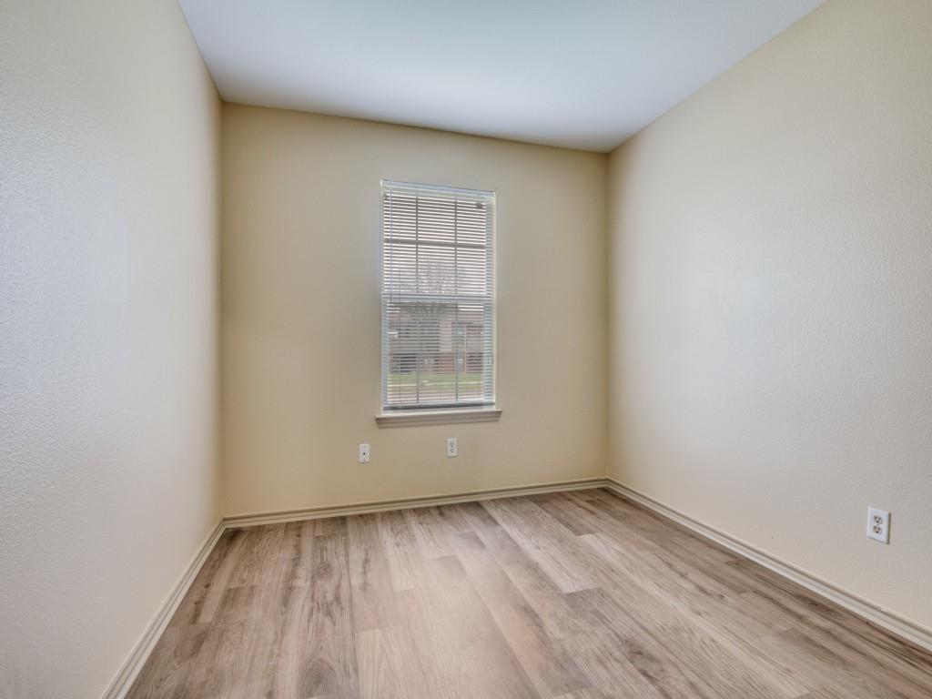 1439 North Bluegrove Road Lancaster, TX 75134 - Photo 6 of 12 a view of an empty room with wooden floor and a window