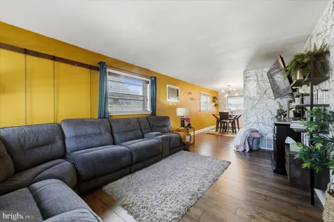 a living room with furniture wooden floor and a flat screen tv