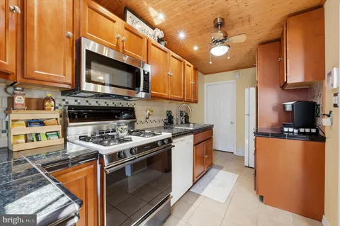 a kitchen with stainless steel appliances granite countertop a stove top oven a sink dishwasher and cabinets with wooden floor