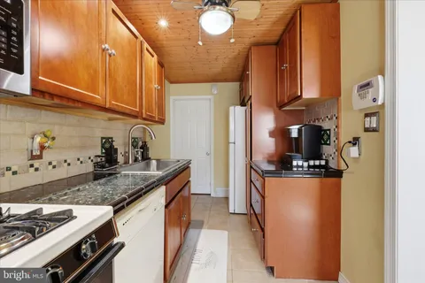 a kitchen with stainless steel appliances granite countertop a sink a stove and a refrigerator
