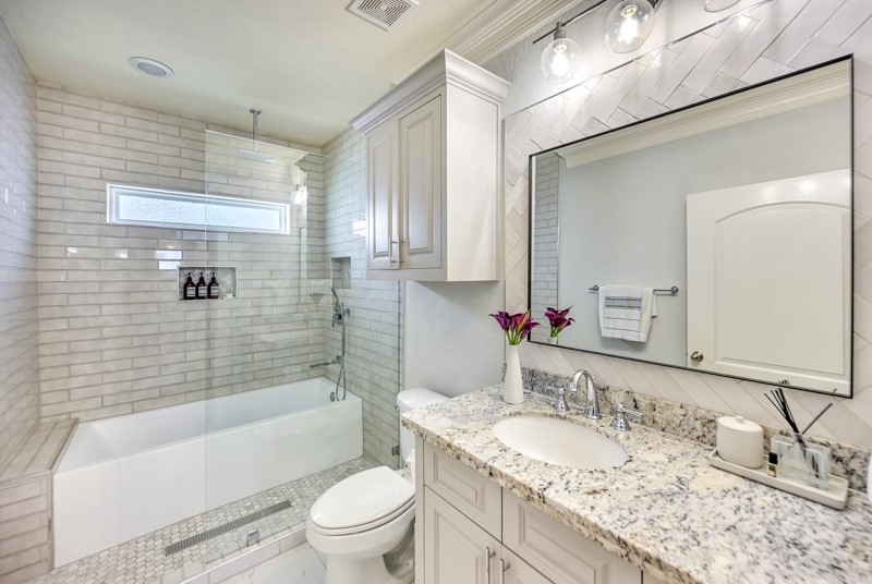 1122 East 23rd Street Houston, TX 77009 - Photo 15 of 23 Stylish secondary bathroom featuring granite countertops, updated tilework, large soaking tub and convenient access for two bedrooms.