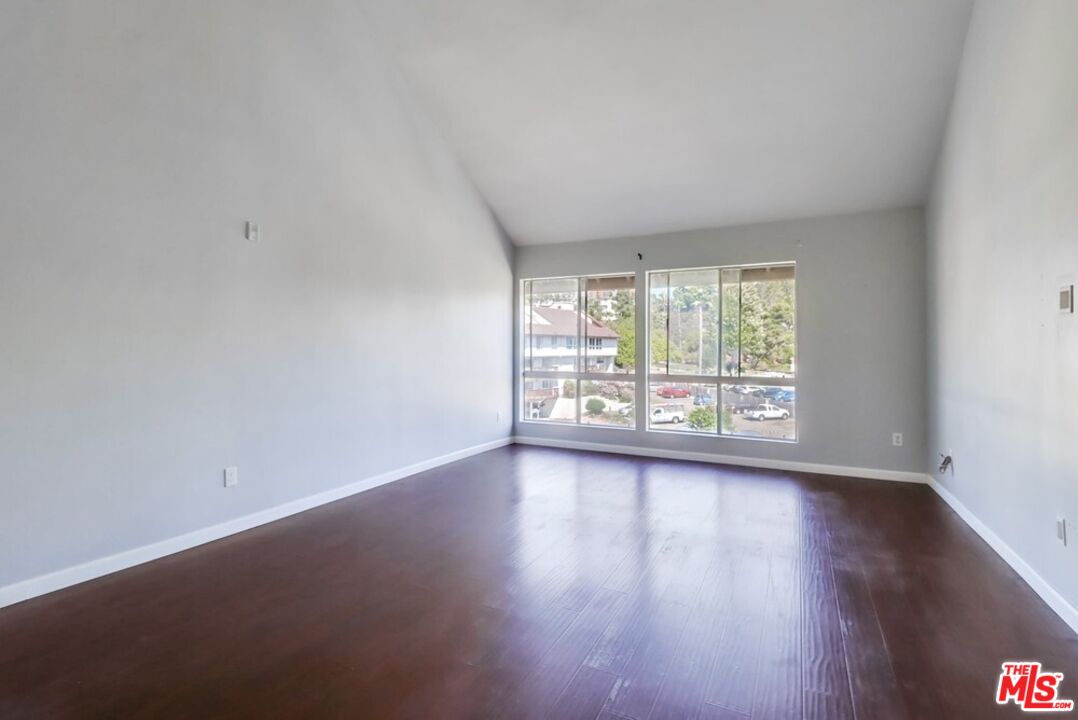 6171 Rancho Mission Road, Unit 317 San Diego, CA 92108 - Photo 3 of 26 a view of an empty room with wooden floor and a window