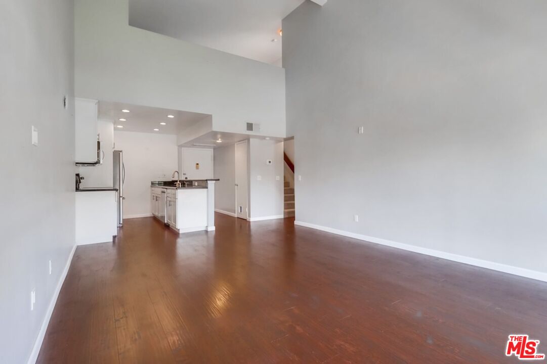 6171 Rancho Mission Road, Unit 317 San Diego, CA 92108 - Photo 5 of 26 a view of kitchen with refrigerator and wooden floor