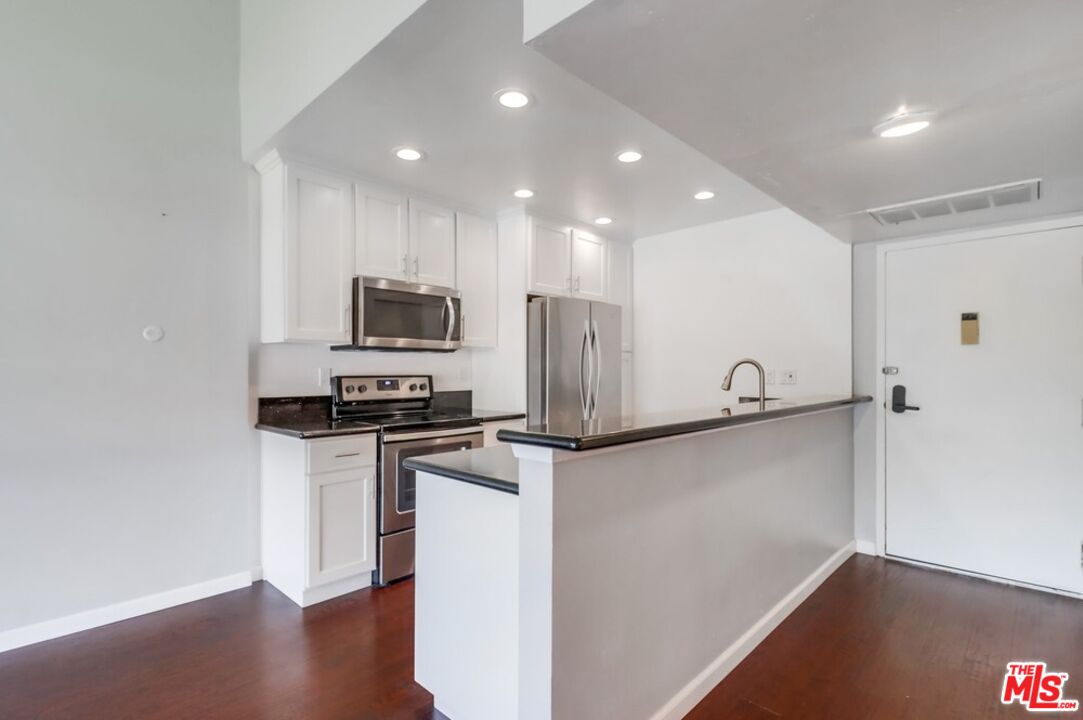 6171 Rancho Mission Road, Unit 317 San Diego, CA 92108 - Photo 7 of 26 a kitchen with stainless steel appliances a refrigerator and a stove top oven