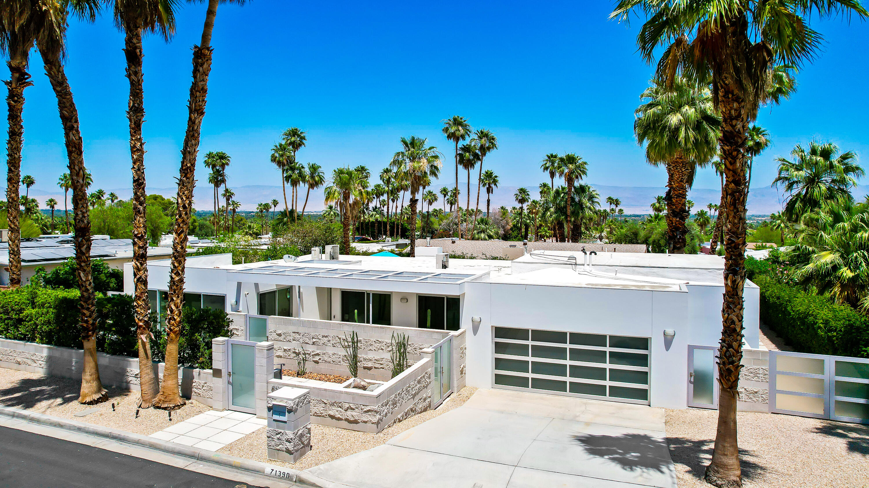 71390 Gardess Road Rancho Mirage, CA 92270 - Photo 3 of 54 a view of a white house with a yard and potted plants