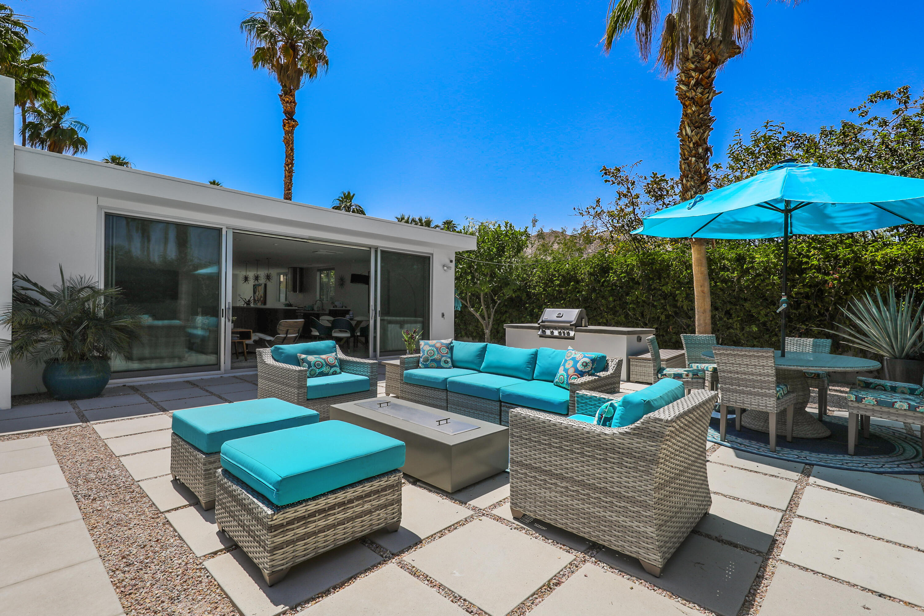 71390 Gardess Road Rancho Mirage, CA 92270 - Photo 44 of 54 a view of a patio with couches chairs under an umbrella with a fire pit