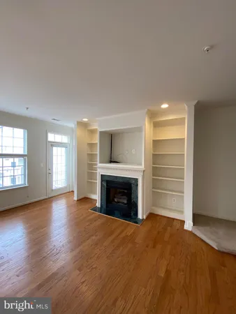 a view of empty room with a fireplace and wooden floor
