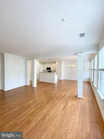 a view of a room with wooden floor and window