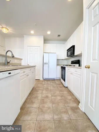 a kitchen with stainless steel appliances a stove top oven a sink and a refrigerator
