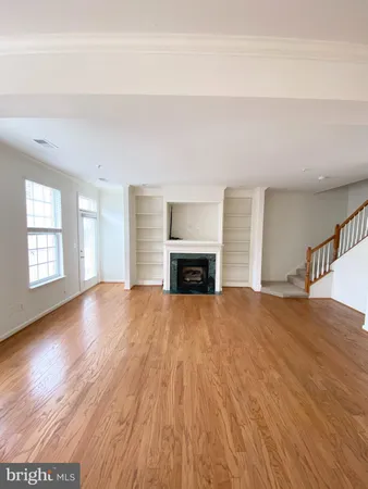 a view of an empty room with window and fireplace