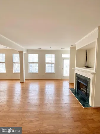 a view of empty room with fireplace and wooden floor