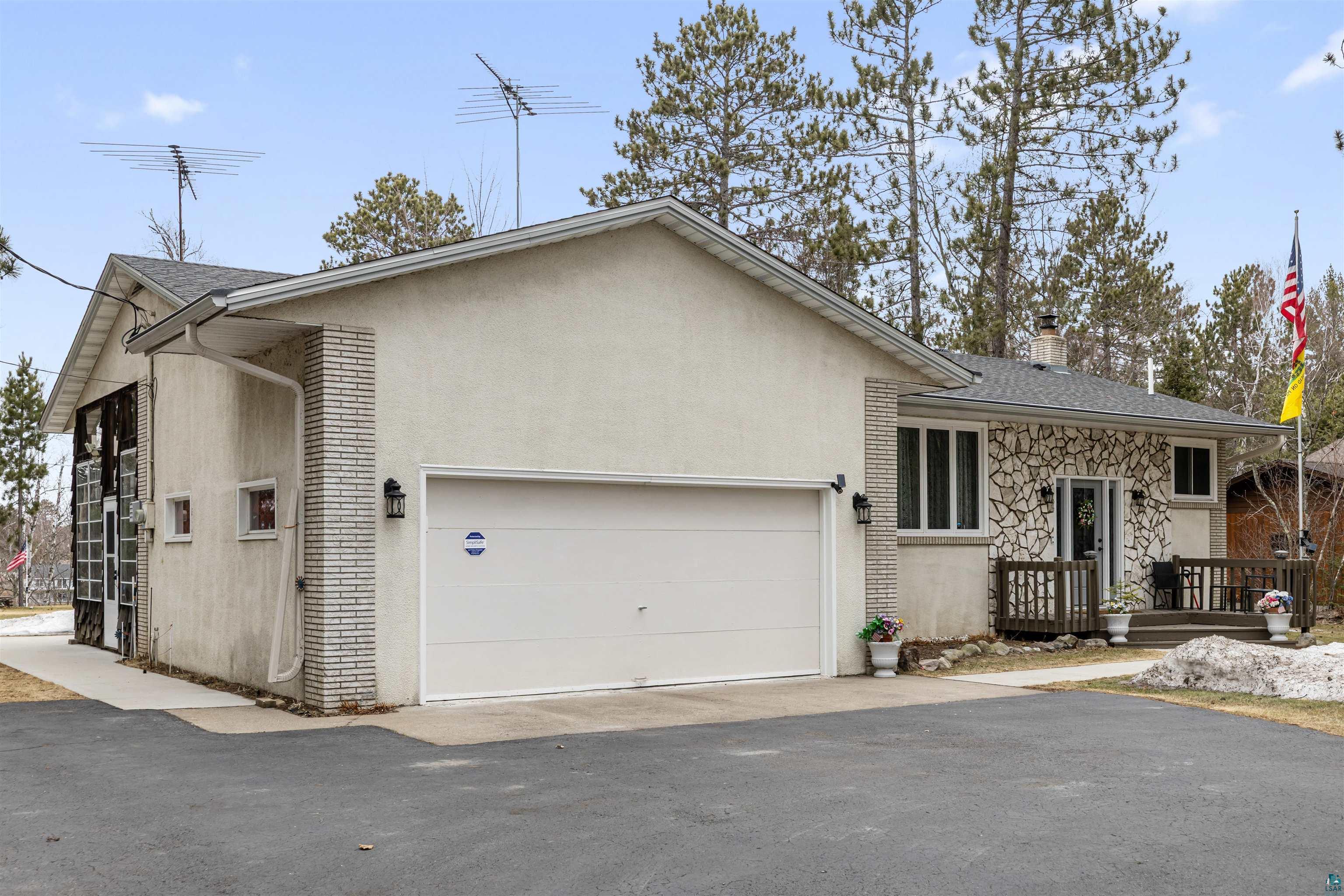 View of front of property featuring a garage, driveway, and a chimney