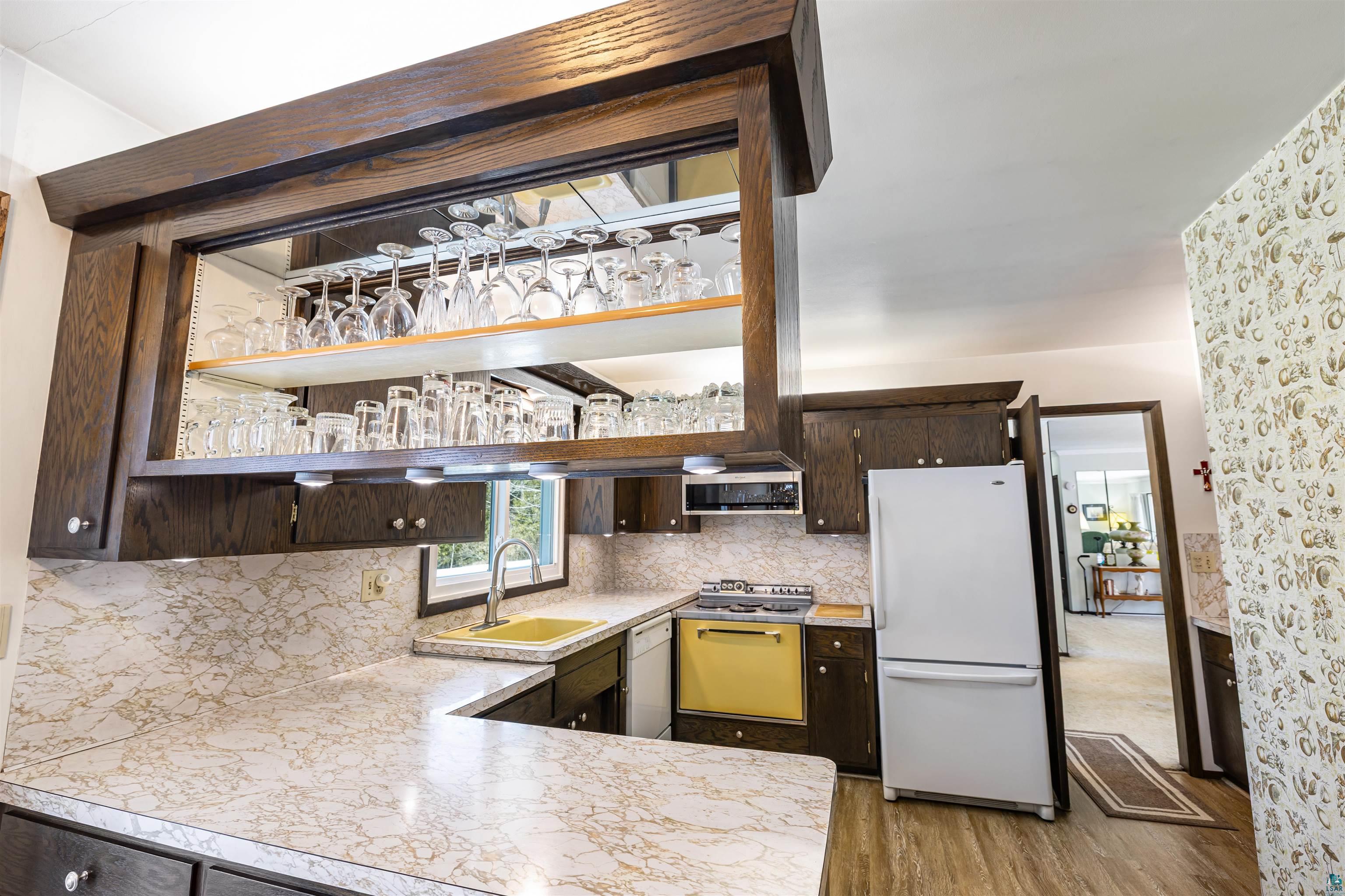 3975 Long Lake Shores Road Eveleth, MN 55734 - Photo 13 of 79 Kitchen with dark wood finish cabinetry, white appliances, light countertops, and tasteful backsplash