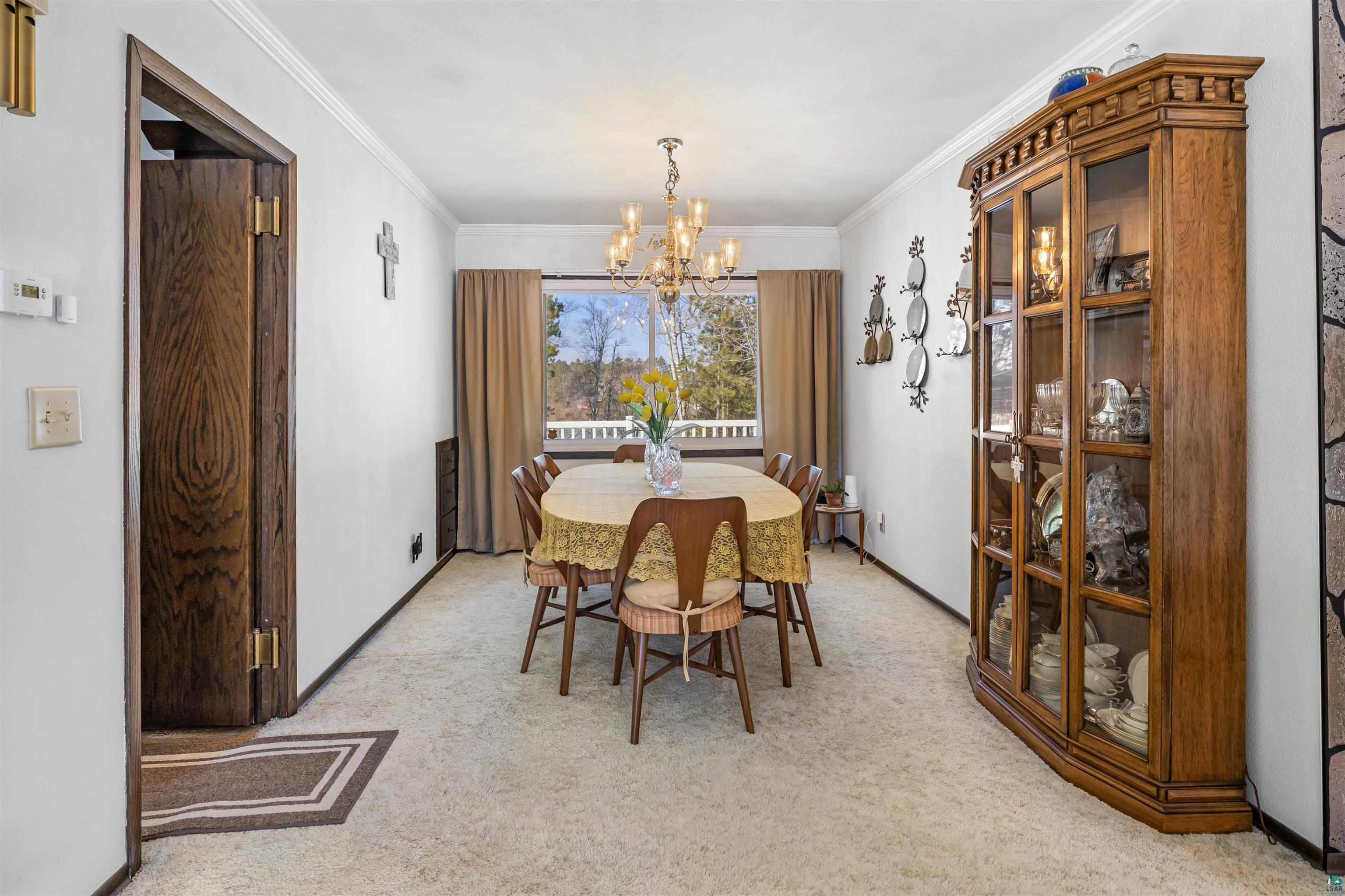 3975 Long Lake Shores Road Eveleth, MN 55734 - Photo 24 of 79 Dining room featuring ornamental molding, suspended lighting, and light carpet