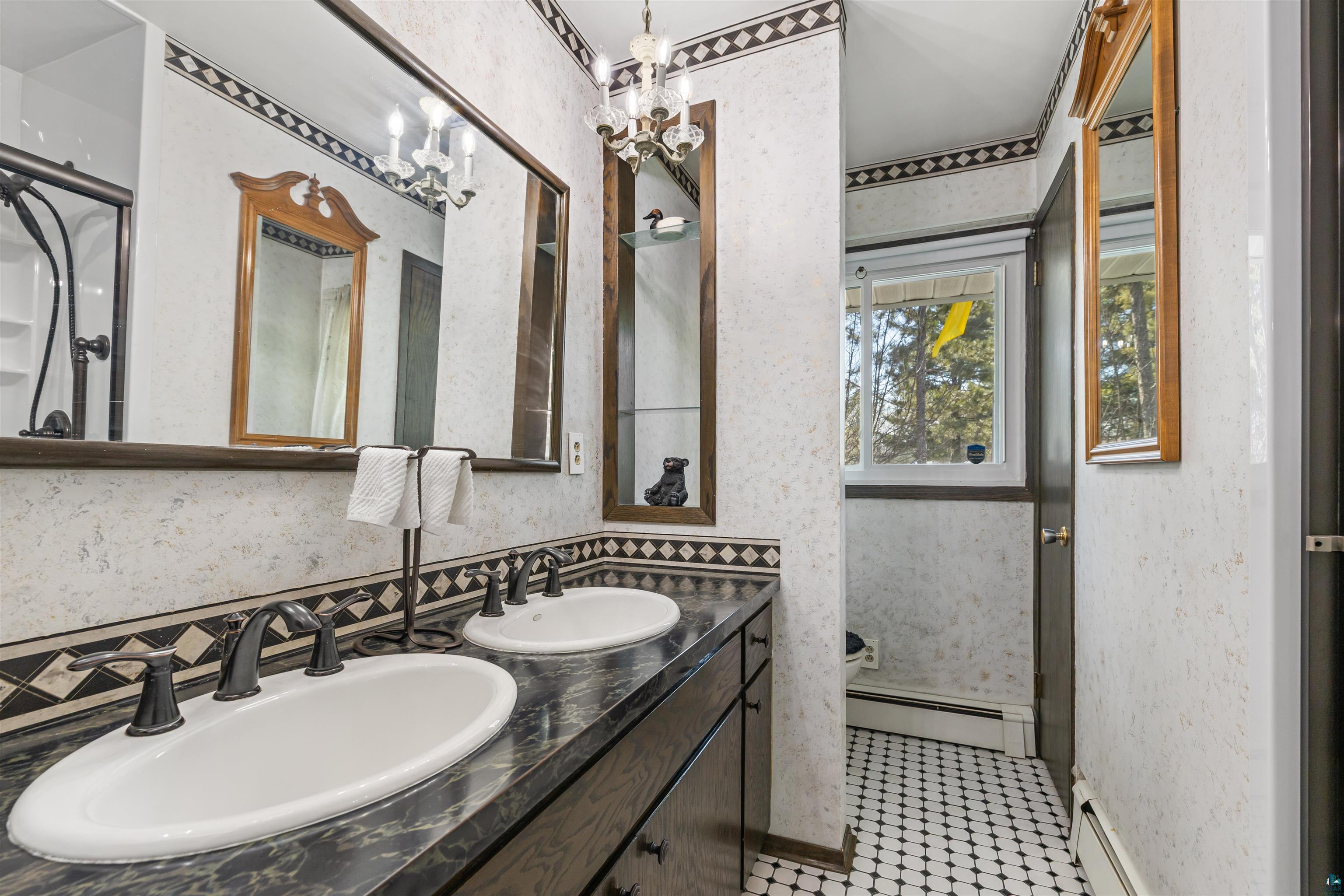 3975 Long Lake Shores Road Eveleth, MN 55734 - Photo 37 of 79 Full bath featuring wallpapered walls, a baseboard heating unit, double vanity, a shower stall, and suspended lighting