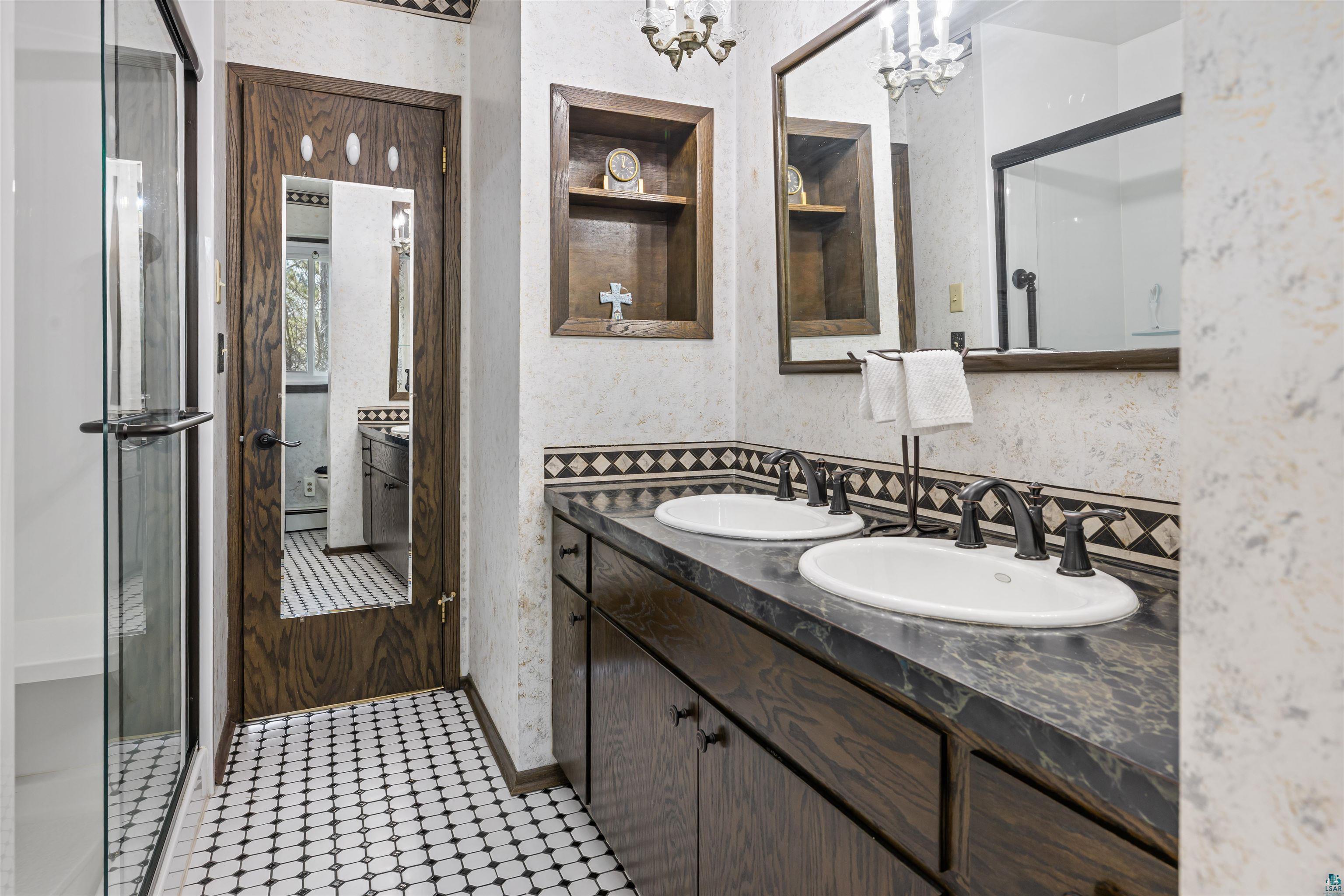 3975 Long Lake Shores Road Eveleth, MN 55734 - Photo 38 of 79 Bathroom featuring double vanity, built in shelves, wallpapered walls, a stall shower, and hanging lights