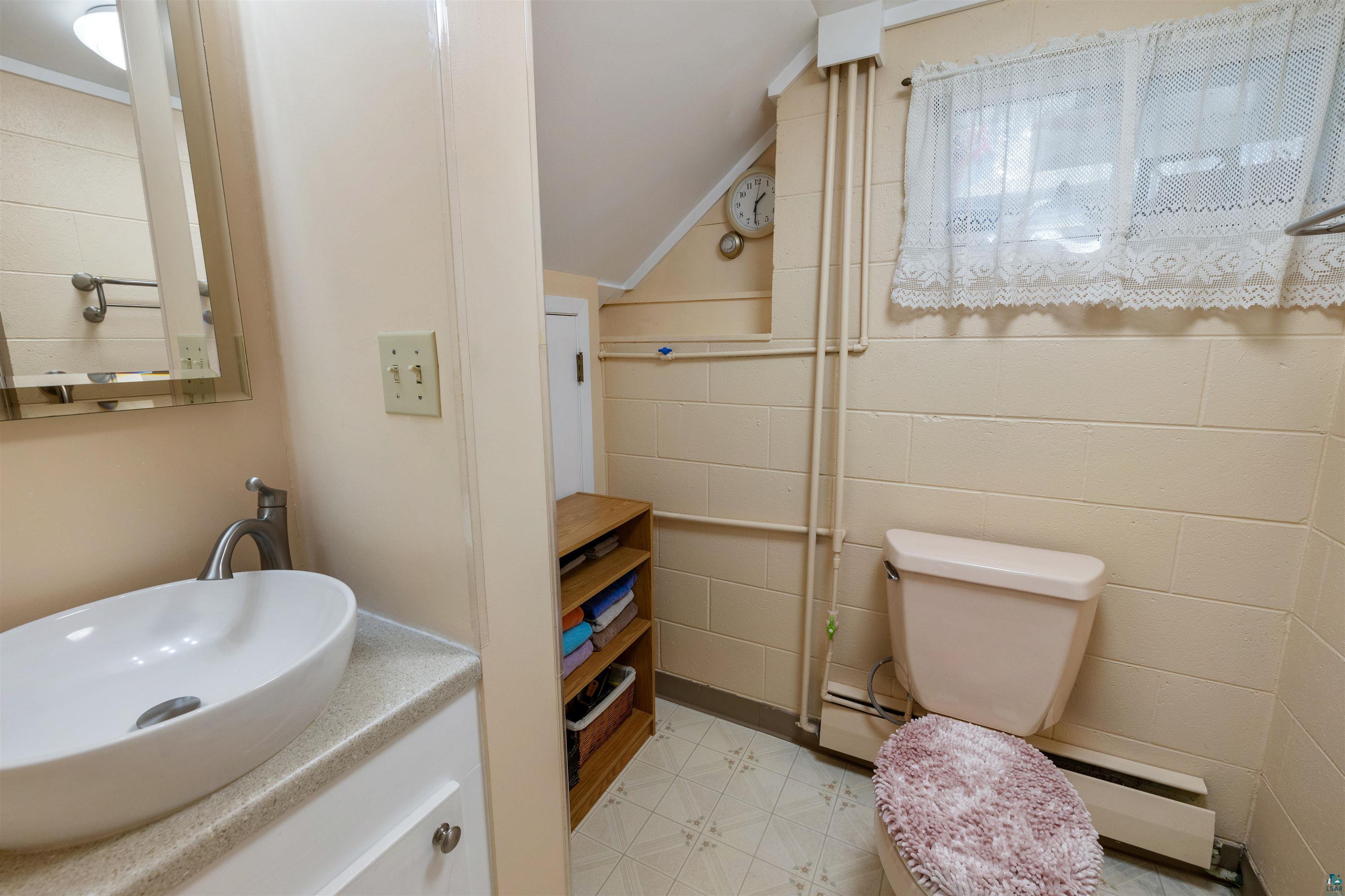 3975 Long Lake Shores Road Eveleth, MN 55734 - Photo 44 of 79 Bathroom with vanity, light floors, lofted ceiling, a baseboard radiator, and concrete block wall