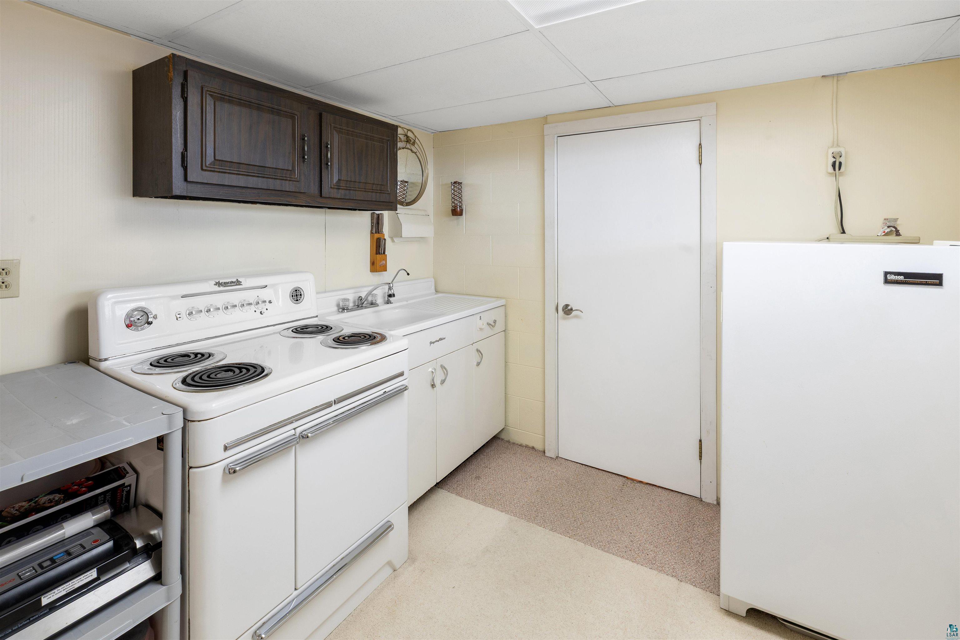 3975 Long Lake Shores Road Eveleth, MN 55734 - Photo 46 of 79 Kitchen featuring white appliances, light countertops, and a paneled ceiling