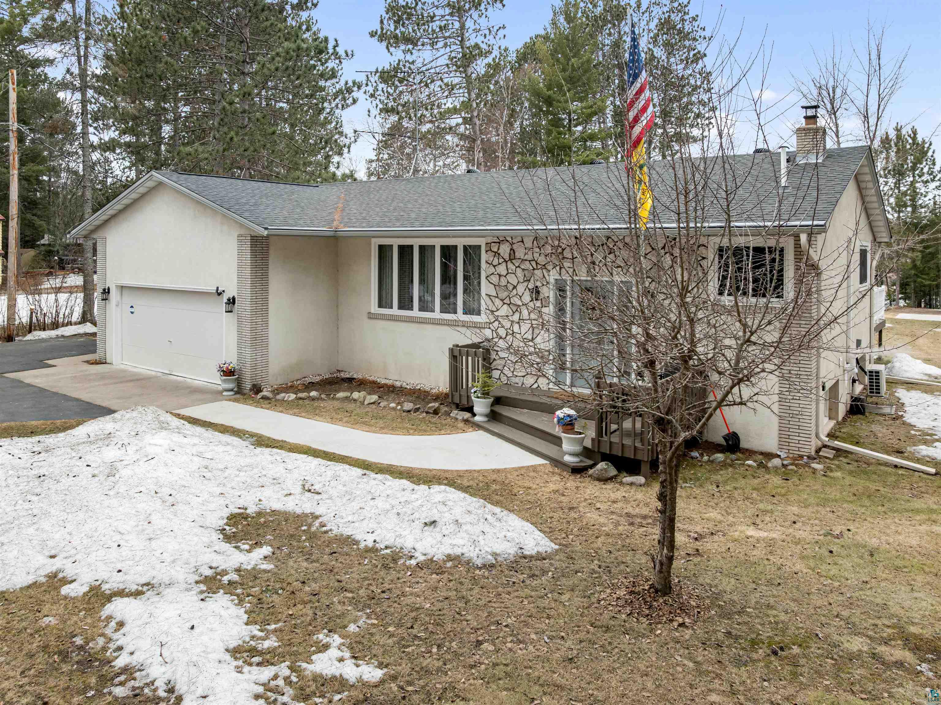 3975 Long Lake Shores Road Eveleth, MN 55734 - Photo 55 of 79 View of front facade featuring a shingled roof, a chimney, a garage, stucco siding, and driveway