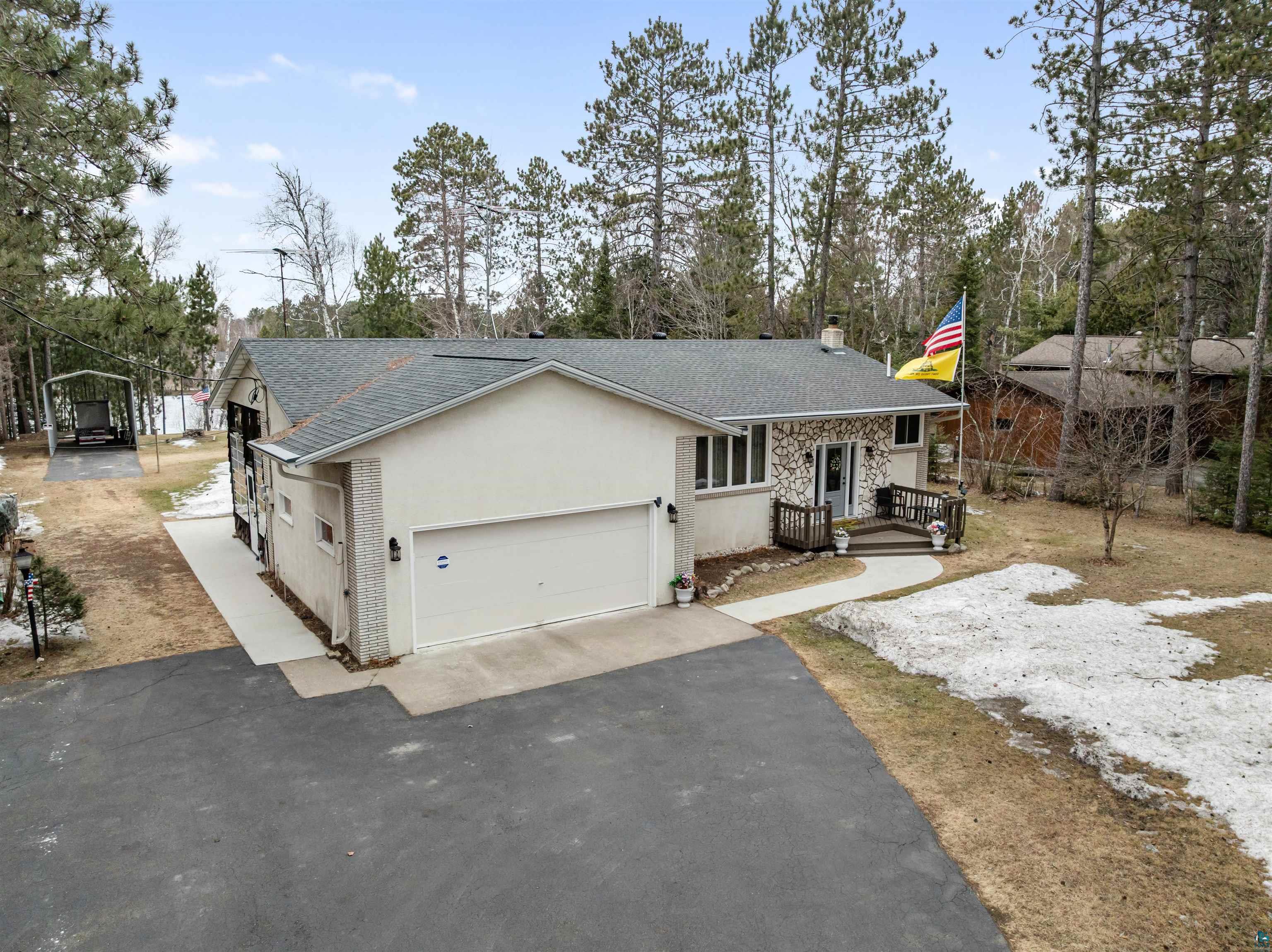 3975 Long Lake Shores Road Eveleth, MN 55734 - Photo 60 of 79 View of front of property with asphalt driveway, roof with shingles, stucco siding, a chimney, and a garage