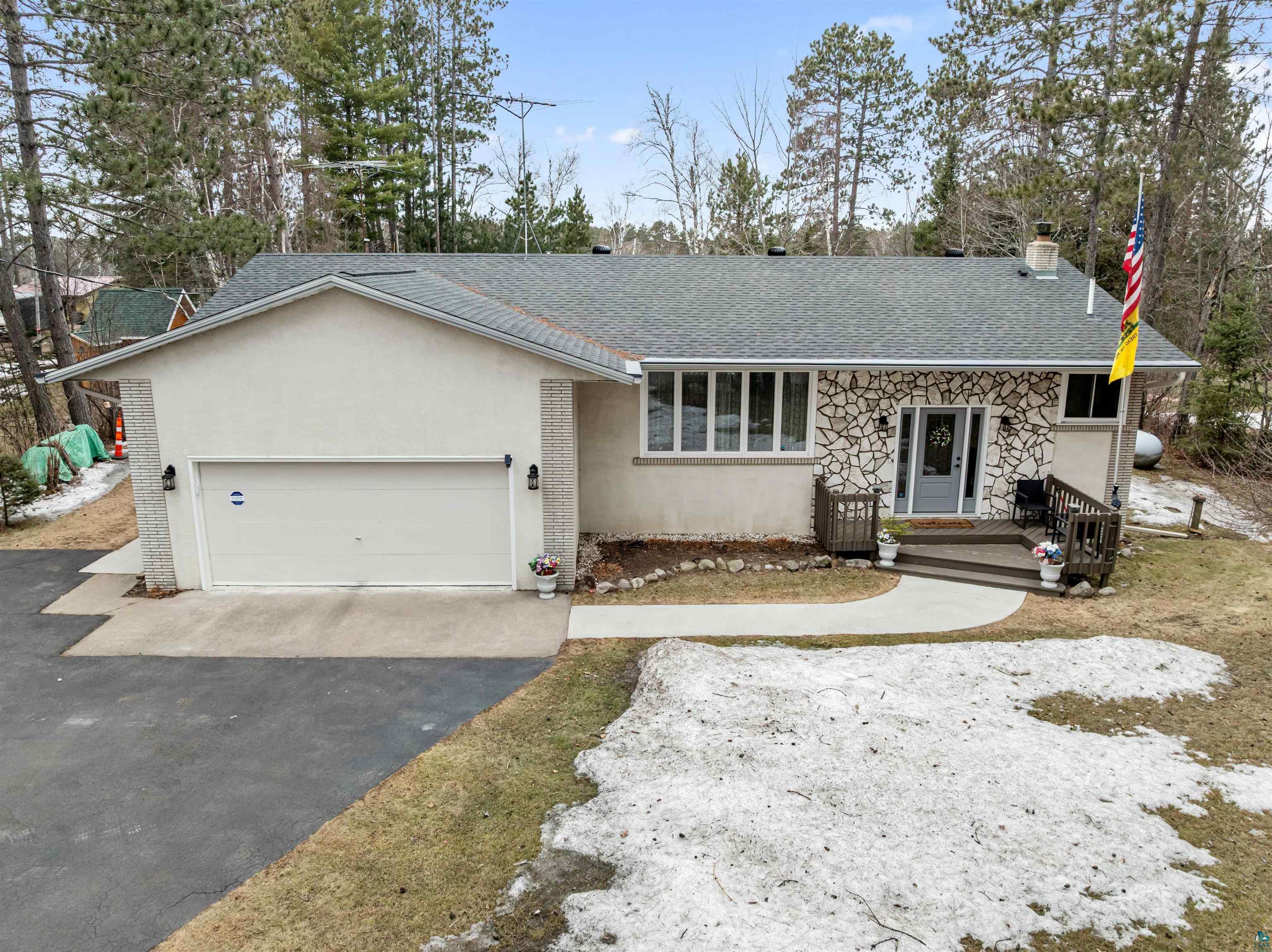 3975 Long Lake Shores Road Eveleth, MN 55734 - Photo 7 of 79 View of front facade featuring asphalt driveway, a chimney, an attached garage, roof with shingles, and stucco siding