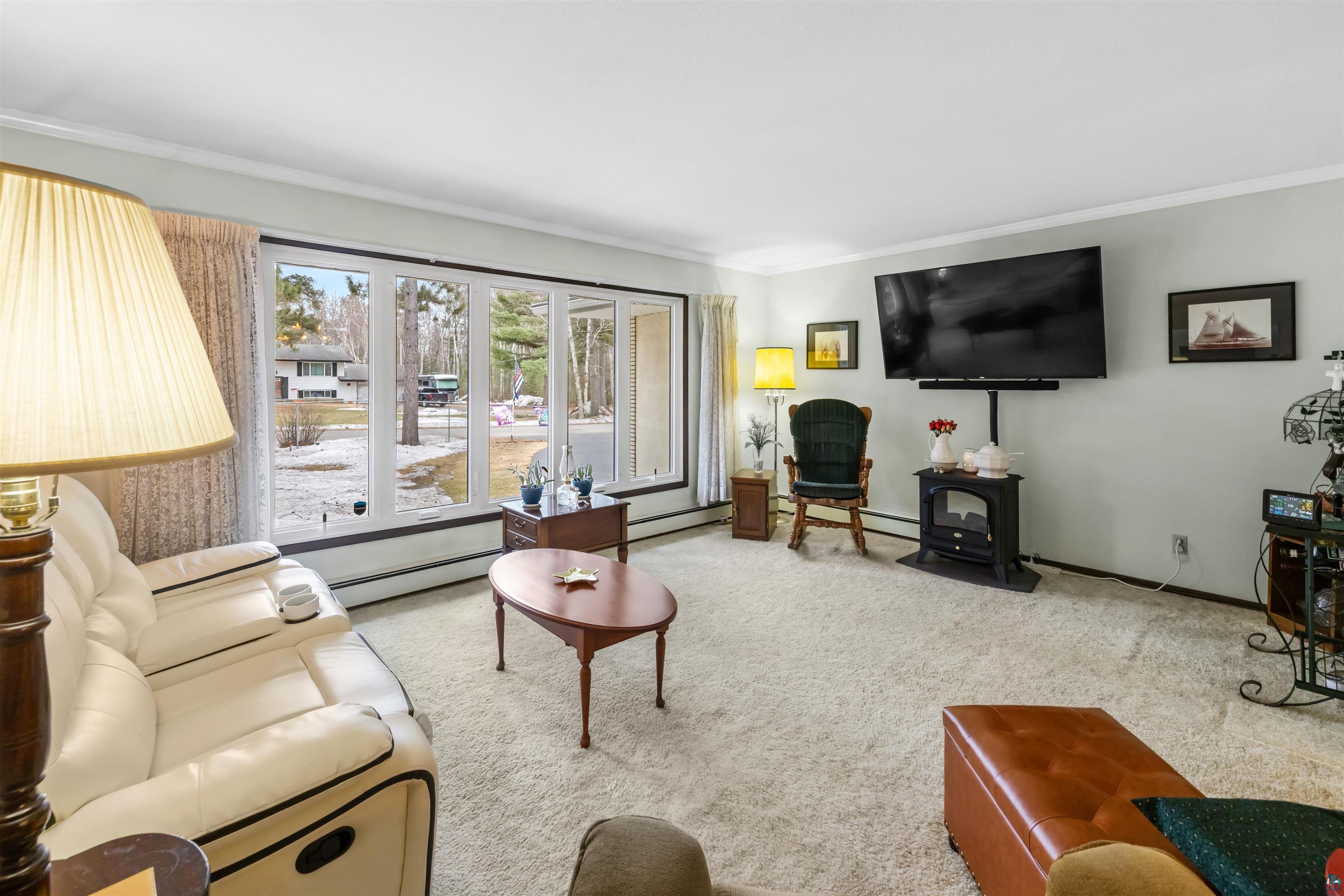 3975 Long Lake Shores Road Eveleth, MN 55734 - Photo 10 of 79 Carpeted living room with ornamental molding and a baseboard heating unit