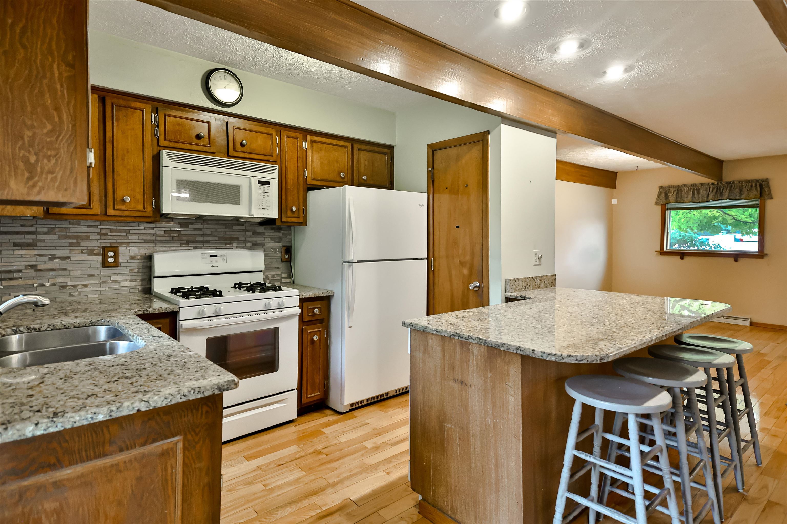 4520 Guilford Road Rockford, IL 61107 - Photo 13 of 28 a kitchen with stainless steel appliances granite countertop a stove a refrigerator a sink dishwasher and wooden cabinets with wooden floor