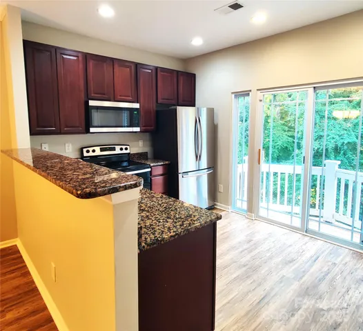 a kitchen with granite countertop a refrigerator and a sink