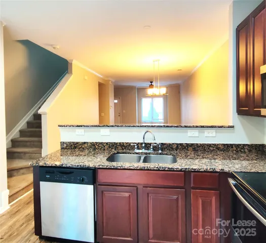 a kitchen with granite countertop a sink and cabinets
