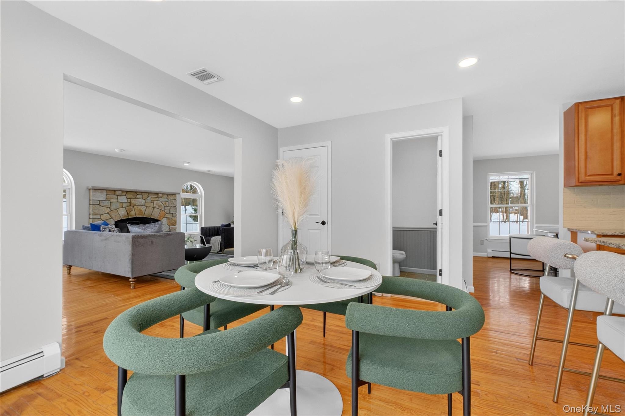 33 Berea Road Walden, NY 12586 - Photo 16 of 44 Dining room featuring a stone fireplace, a baseboard radiator, light wood finished floors, recessed lighting, and healthy amount of natural light
