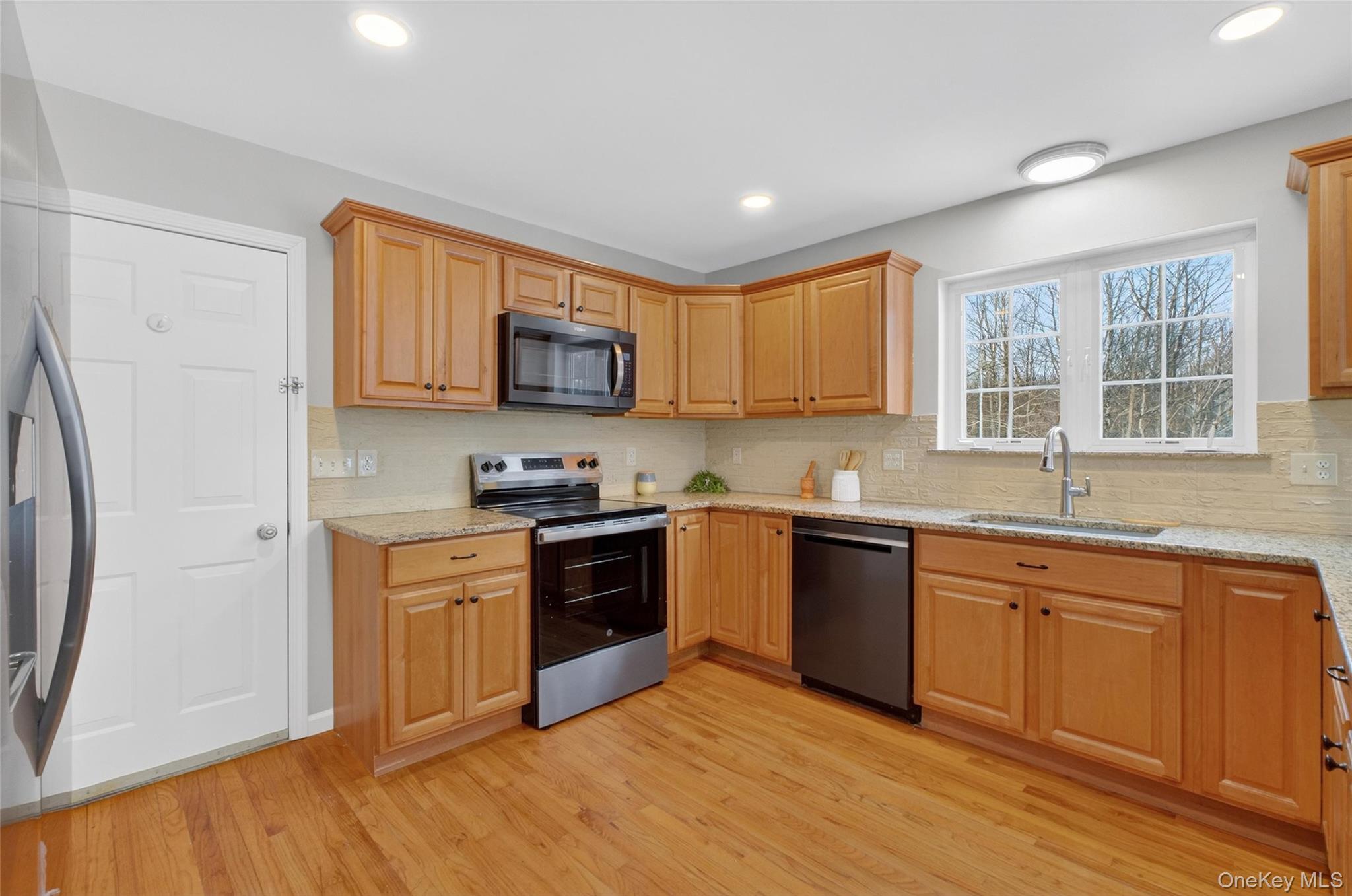 33 Berea Road Walden, NY 12586 - Photo 19 of 44 Kitchen with stainless steel appliances, light stone counters, decorative backsplash, light wood finished floors, and recessed lighting