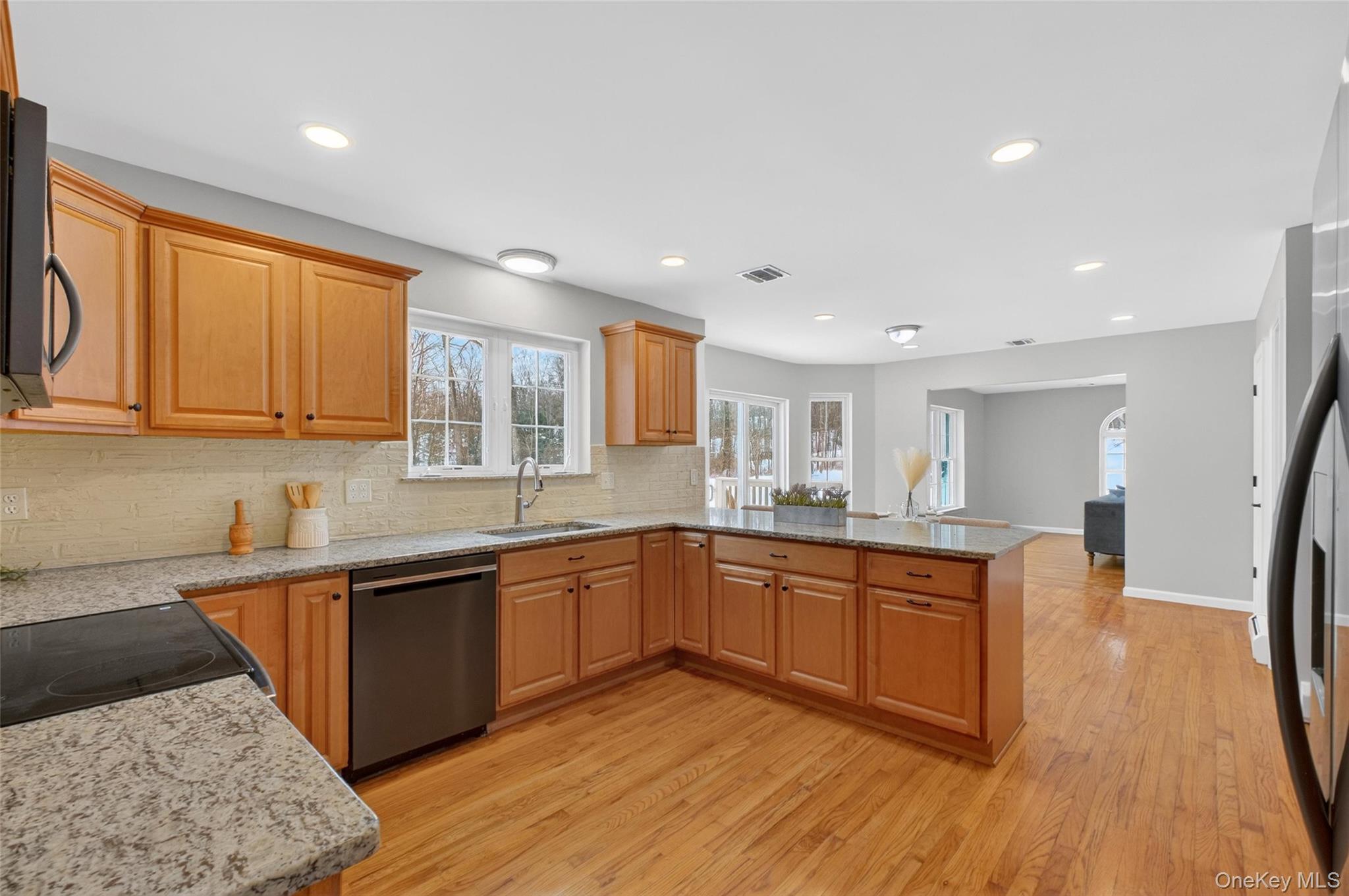 33 Berea Road Walden, NY 12586 - Photo 20 of 44 Kitchen featuring light stone counters, dishwasher, a peninsula, light wood finished floors, and freestanding refrigerator