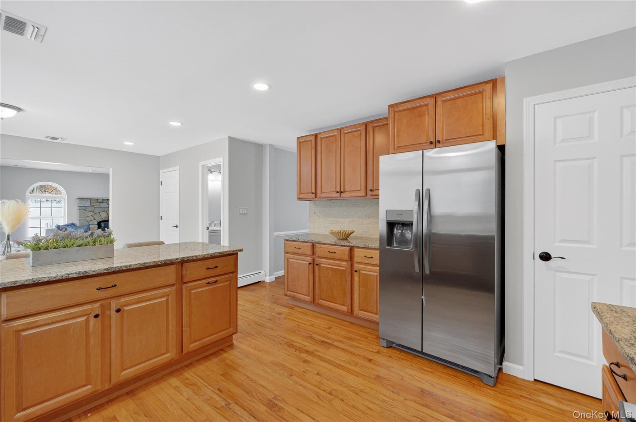 33 Berea Road Walden, NY 12586 - Photo 21 of 44 Kitchen featuring light stone counters, stainless steel fridge, light wood-type flooring, decorative backsplash, and recessed lighting