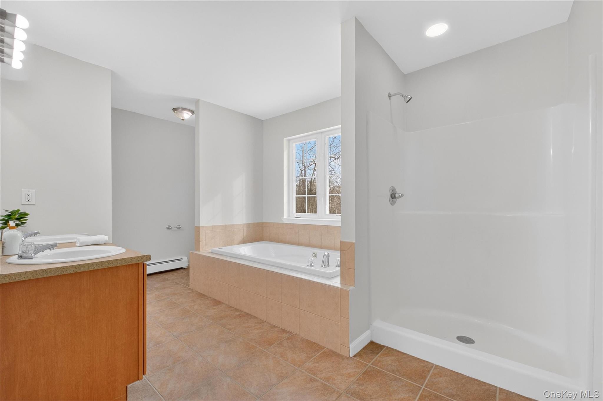 33 Berea Road Walden, NY 12586 - Photo 26 of 44 Full bath with a garden tub, light tile patterned flooring, double vanity, and a stall shower