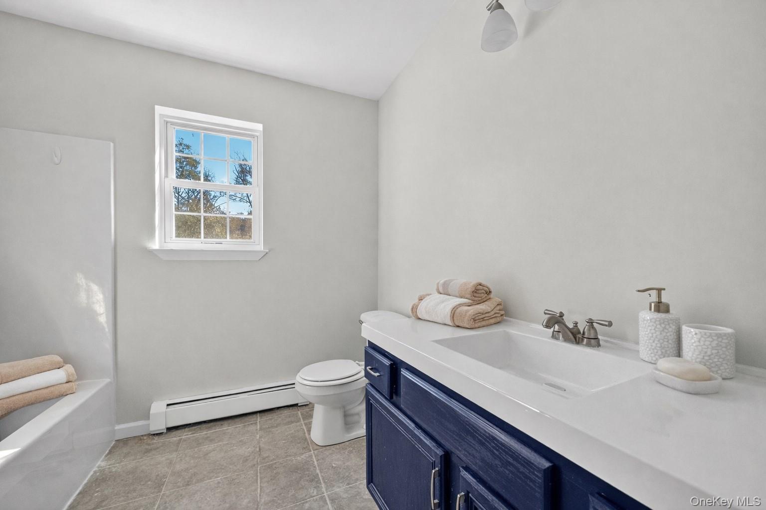 33 Berea Road Walden, NY 12586 - Photo 34 of 44 Bathroom with baseboard heating, vanity, light tile patterned floors, and shower / bathtub combination