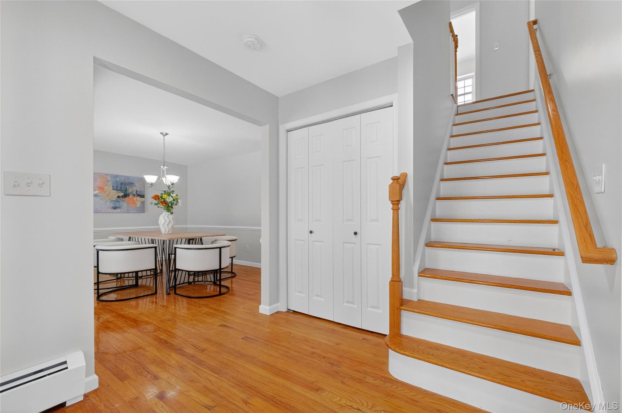 33 Berea Road Walden, NY 12586 - Photo 5 of 44 Stairway with a baseboard radiator, wood finished floors, and a chandelier